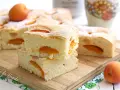 Fette di torta alle albicocche cremosa, soffice e profumata, con albicocche fresche e zucchero a velo.