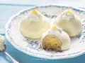 Deliziose tortine al limone, con un ripieno cremoso e una decorazione di panna e scorza di limone.