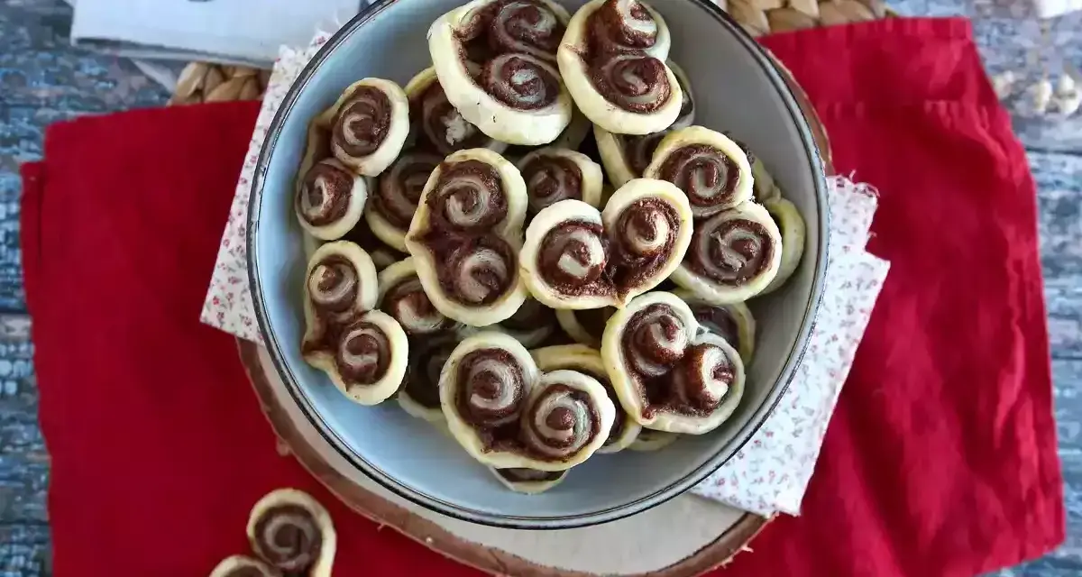 Cuoricini di pasta sfoglia rettangolare con Nutella, un dolce goloso pronto da gustare.
