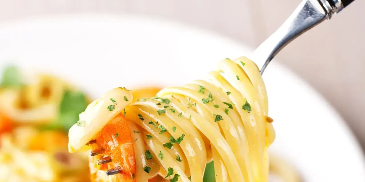 Un primo piatto invitante: spaghetti con gamberetti succulenti e prezzemolo fresco, pronti per essere gustati.