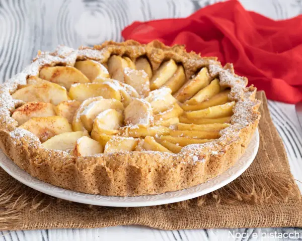 Una deliziosa crostata di mele, con mele a fette disposte a raggiera e spolverata di zucchero a velo.