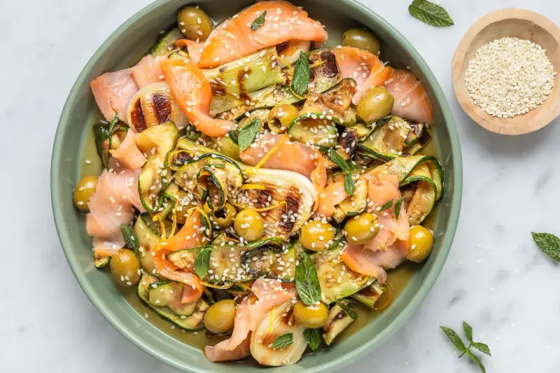 Insalata colorata con salmone affumicato, zucchine grigliate, olive e semi di sesamo. Un'idea per piatti freddi veloci e gustosi.