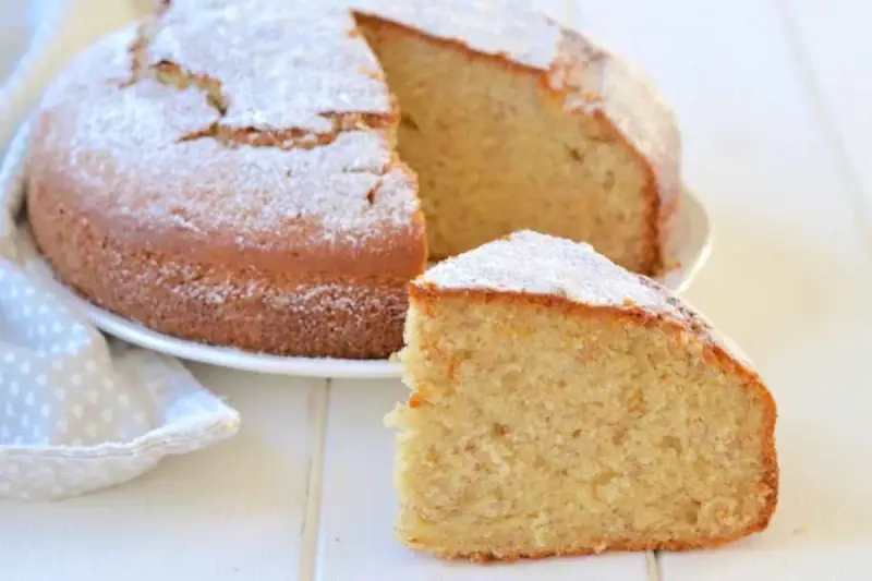 Una soffice torta di banane, spolverata di zucchero a velo, con una fetta tagliata per gustarla.
