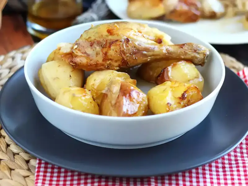 Un invitante pollo al forno con patate dorate, un classico piatto che profuma di casa.