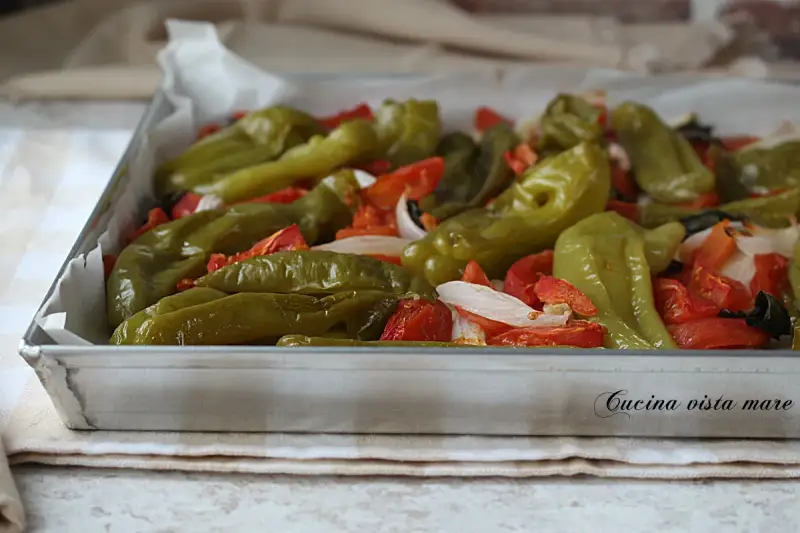 Friggitelli al forno con pomodori e cipolla, un contorno saporito e colorato, pronto per essere gustato.